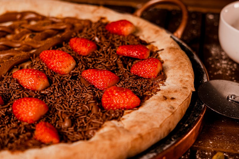 Dessert pizza with Nutella, strawberries and powdered sugar